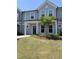 Charming townhome with light gray siding, a covered porch, and a well-manicured lawn at 1218 S Franklin St, Wake Forest, NC 27587