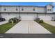 Three-car garage with concrete driveway and well-maintained landscaping in front of townhomes at 1218 S Franklin St, Wake Forest, NC 27587