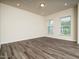 Bright living room with two windows, wood-look flooring, and recessed lighting at 1218 S Franklin St, Wake Forest, NC 27587