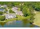 Serene aerial view of a community with lakefront homes, a golf course, and lush trees at 12527 Bellstone Ln, Raleigh, NC 27614