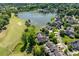 Stunning aerial view of homes bordering a lush green golf course and a tranquil lake at 12527 Bellstone Ln, Raleigh, NC 27614