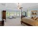Bright bedroom featuring tray ceiling, large windows and a comfortable sitting area at 12527 Bellstone Ln, Raleigh, NC 27614