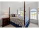 Cozy bedroom with four-poster bed, natural light, and a view of the lake at 12527 Bellstone Ln, Raleigh, NC 27614