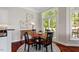 Sunlit dining area features a round table, hardwood floors, artwork, and a large window at 12527 Bellstone Ln, Raleigh, NC 27614