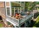 Multi-tiered deck features outdoor seating and dining area; overlooks lawn and wooded area at 12527 Bellstone Ln, Raleigh, NC 27614