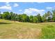 Picturesque view of a well-maintained golf course with green grass and mature trees at 12527 Bellstone Ln, Raleigh, NC 27614