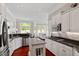 Bright kitchen features white cabinets, stainless steel appliances, a granite island, and hardwood floors at 12527 Bellstone Ln, Raleigh, NC 27614