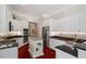 Bright kitchen features a granite island, white cabinets, stainless steel appliances, and hardwood floors at 12527 Bellstone Ln, Raleigh, NC 27614