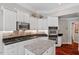 Modern kitchen features a granite island, white cabinets, stainless steel appliances, and hardwood floors at 12527 Bellstone Ln, Raleigh, NC 27614