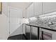 Stylish wet bar features stainless steel appliances, mosaic tile backsplash, and sleek black countertops at 12527 Bellstone Ln, Raleigh, NC 27614