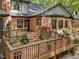 Back deck area with a grill and various plants in pots, with a brick exterior of the house at 12537 Birchfalls Dr, Raleigh, NC 27614