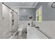 Bright bathroom featuring a soaking tub, glass shower, and sleek tile at 12537 Birchfalls Dr, Raleigh, NC 27614
