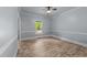 Bright bedroom with hardwood floors, neutral paint, and a view of the green yard at 12537 Birchfalls Dr, Raleigh, NC 27614