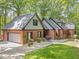 Charming brick home with attached garage, complimented by lush landscaping and a well manicured lawn at 12537 Birchfalls Dr, Raleigh, NC 27614