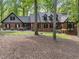 Charming brick home featuring black shutters, complemented by lush landscaping and mature trees in a serene setting at 12537 Birchfalls Dr, Raleigh, NC 27614
