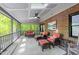 Relaxing screened porch with comfortable seating, brick accent wall, and wooded view at 12537 Birchfalls Dr, Raleigh, NC 27614