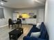 Open floorplan view of a living room featuring a kitchen, dining area and a blue sofa at 130 S Estes Dr # C-5, Chapel Hill, NC 27514