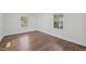 Spacious bedroom with hardwood floors, white walls, and natural light from two windows at 1316 Glenwood Ave, Raleigh, NC 27605