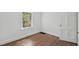 This bedroom features hardwood floors, a bright window, and white trim and doors at 1316 Glenwood Ave, Raleigh, NC 27605