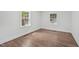 Empty bedroom with hardwood floors and two windows providing natural light at 1316 Glenwood Ave, Raleigh, NC 27605