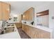Galley kitchen featuring light wood cabinets, white countertops, modern flooring and stainless steel sink at 1316 Glenwood Ave, Raleigh, NC 27605
