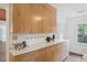 Galley kitchen featuring light wood cabinets, white countertops, modern flooring and stainless steel sink at 1316 Glenwood Ave, Raleigh, NC 27605