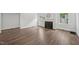 Sunlit living room featuring a classic fireplace, hardwood floors, and plenty of light from surrounding windows at 1316 Glenwood Ave, Raleigh, NC 27605