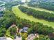 Aerial view of brick estate home surrounded by lush greenery, a nearby golf course, and a manicured lawn at 1501 Samuel Wait Ln, Wake Forest, NC 27587