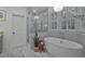 Luxurious bathroom with a standalone tub, glass-enclosed shower, modern fixtures, and elegant tile work at 1501 Samuel Wait Ln, Wake Forest, NC 27587