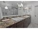 Elegant bathroom featuring double sinks, granite countertops, modern lighting, and a large mirror at 1501 Samuel Wait Ln, Wake Forest, NC 27587