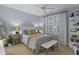 Stylish bedroom featuring soft blue walls, a cushioned bench, and a bright window with plantation shutters at 1501 Samuel Wait Ln, Wake Forest, NC 27587