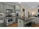 Charming kitchen features an island with seating, stainless steel appliances, and hardwood floors at 1501 Samuel Wait Ln, Wake Forest, NC 27587