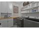 Functional laundry room with ample shelving, a butcher block counter, and modern washer and dryer units at 1501 Samuel Wait Ln, Wake Forest, NC 27587