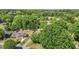 Aerial view showcases a home with a well-maintained lawn surrounded by mature trees and a wooded backdrop at 1612 Regency Dr, Burlington, NC 27215