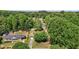 Aerial view of a home with a lush green yard and mature trees, surrounded by neighborhood at 1612 Regency Dr, Burlington, NC 27215