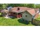 Aerial view of a backyard with gazebo, patio with fire pit, green lawn, and mature trees at 1612 Regency Dr, Burlington, NC 27215