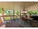 Relaxing covered deck featuring a ceiling fan, outdoor seating, and a view of the backyard gazebo at 1612 Regency Dr, Burlington, NC 27215