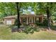 Charming brick home with a covered porch, mature trees, and well-maintained landscaping at 1612 Regency Dr, Burlington, NC 27215