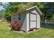 Outdoor shed with a side window and an oversize barn door is surrounded by greenery at 1612 Regency Dr, Burlington, NC 27215