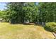 Spacious backyard featuring a chicken coop, shed, and raised garden beds among mature trees at 170 Homestead Rd, Angier, NC 27501