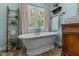 Elegant bathroom showcasing a freestanding tub with vintage fixtures, alongside a rustic ladder at 170 Homestead Rd, Angier, NC 27501