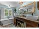 Bright bathroom features a vintage-style vanity, freestanding tub, and a large window at 170 Homestead Rd, Angier, NC 27501