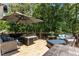 Spacious deck featuring a modern outdoor seating area, umbrella, and wooded views at 170 Homestead Rd, Angier, NC 27501