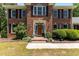 Charming brick home entrance with a wooden door, manicured shrubs, and lovely landscaping at 170 Homestead Rd, Angier, NC 27501