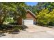 Brick home showcasing a two-car garage, ample driveway space, and verdant landscaping at 170 Homestead Rd, Angier, NC 27501