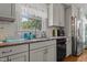 Kitchen featuring grey cabinets, granite countertops, stainless steel appliances, and views of the outdoor scenery at 170 Homestead Rd, Angier, NC 27501