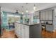Bright open kitchen area with kitchen island, dining area, stainless steel refrigerator, and white appliances at 170 Homestead Rd, Angier, NC 27501