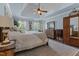 Spacious main bedroom features natural lighting, wood flooring, and a tray ceiling with ceiling fan at 170 Homestead Rd, Angier, NC 27501
