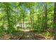 Scenic view of a serene pond surrounded by lush green trees and a natural path at 170 Homestead Rd, Angier, NC 27501