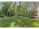 Beautiful backyard featuring mature trees, green grass, and a screened-in porch at 1705 Bridgeport Dr, Raleigh, NC 27615